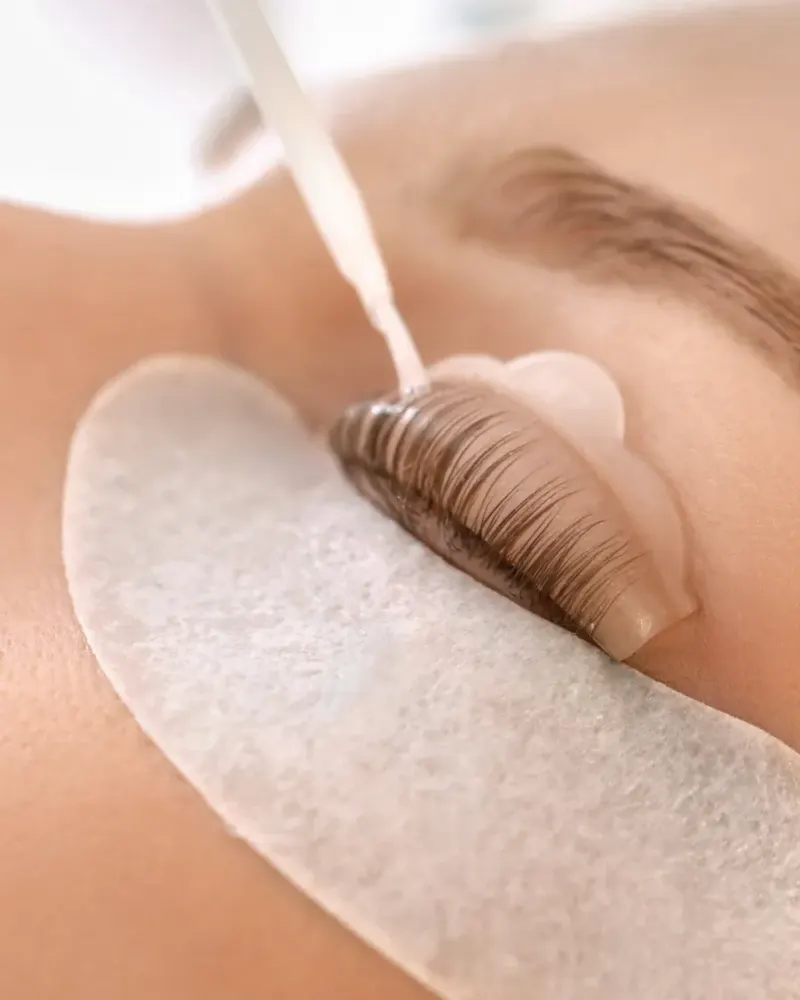 A lash lift in progress: the client's natural lashes pressed up onto a silicone shield as the lifting lotion goes on