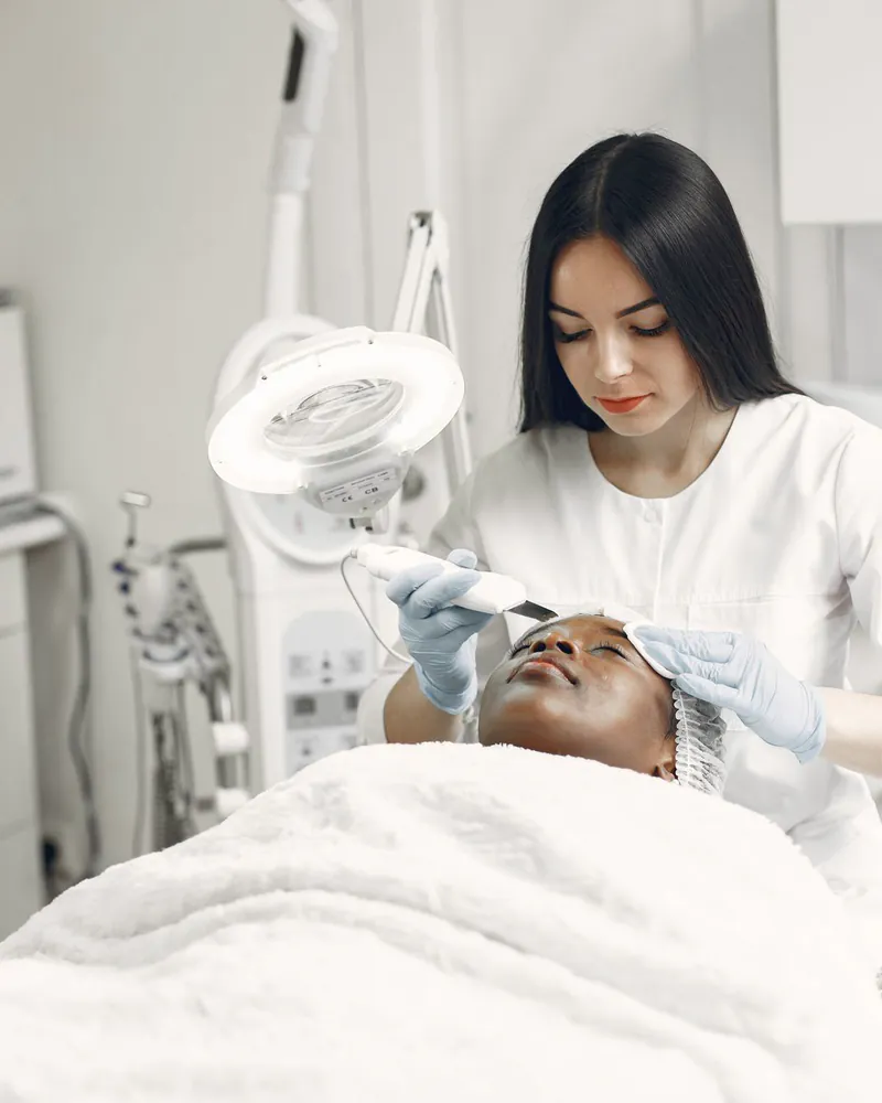 An aesthetician applying a facial treatment to a client