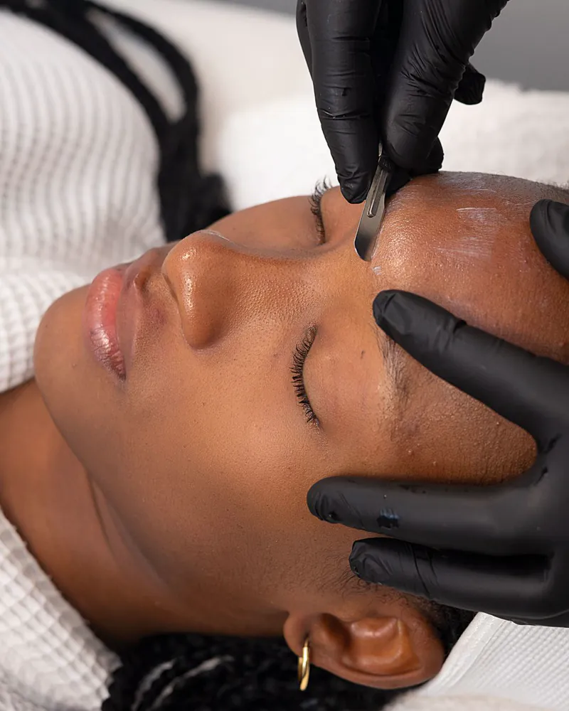 A gloved technician giving a client a spa treatment